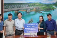 Chủ tịch Ủy ban Mặt trận Tổ quốc Việt Nam tỉnh Quảng Bình Phạm Thị Hân trao bảng tượng trưng số tiền 500 triệu đồng hỗ trợ cho huyện Quảng Ninh.