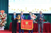 Thừa ủy quyền của Chủ tịch Tổng Liên đoàn Lao động Việt Nam, lãnh đạo Tập đoàn Công nghiệp cao-su Việt Nam và đại diện lãnh đạo Liên đoàn Lao động tỉnh Điện Biên trao Cờ thi đua tập thể lao động xuất sắc cho tập thể Công ty cổ phần cao-su Việt Nam. (Ảnh: TRUNG KIÊN)