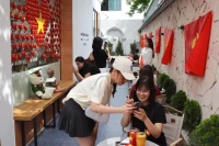Du khách hào hứng "check-in" tại quán cà-phê ở Hà Nội. (Ảnh: nhandan.vn)