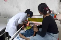 Bác sĩ khoa Nhi tổng hợp, Bệnh viện đa khoa vùng Tây Nguyên thăm khám cho bệnh nhi hóc dị vật đường thở. Ảnh: Quang Nhật.