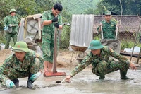 Bộ đội Đồn Biên phòng Tam Hợp, huyện Tương Dương, tỉnh Nghệ An hỗ trợ nhân dân làm đường giao thông. (Ảnh: nhandan.vn)