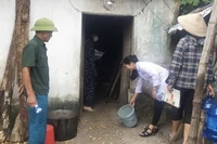 Cán bộ y tế hướng dẫn người dân vệ sinh môi trường sau bão, lụt trên địa bàn huyện Ứng Hòa, Hà Nội.