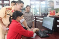 Cảnh sát giao thông hướng dẫn người dân đăng ký xe trên Cổng dịch vụ công.