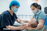 Bác sĩ khám cho bệnh nhi gần 2 tháng tuổi mắc ho gà đang điều trị tại Trung tâm bệnh Nhiệt đới (Bệnh viện Nhi Trung ương). (Ảnh: Minh Quyết/TTXVN)