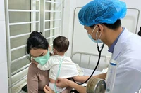 Bác sĩ Khoa Bệnh Nhiệt đới (Bệnh viện Sản-Nhi Nghệ An) khám cho bệnh nhi mắc sởi.