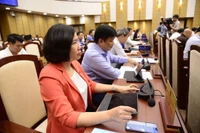 Các đại biểu bấm nút thông qua Nghị quyết.