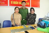 Đối tượng Giàng Thị Chú và Hoàng Cở bị công an bắt giữ cùng tang vật 14 bánh heroin. (Ảnh: QUỲNH TRANG)