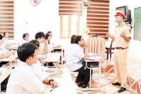 Cán bộ Phòng Cảnh sát giao thông Công an tỉnh Ninh Bình tuyên truyền pháp luật về trật tự an toàn giao thông cho học sinh. (Ảnh VIỆT HÙNG) 