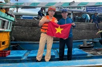 Cảnh sát trao tặng lá cờ cho ngư dân.