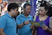 Cán bộ Bảo hiểm xã hội Hà Nội vận động người dân tham gia bảo hiểm xã hội tự nguyện, bảo hiểm y tế hộ gia đình. (Ảnh HSS)