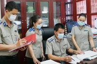 Cán bộ, chấp hành viên Chi cục Thi hành án dân sự huyện Hiệp Hòa (tỉnh Bắc Giang) trao đổi nghiệp vụ giải quyết án. Ảnh: TUỆ AN