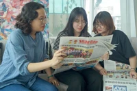 Các bạn trẻ tại Thành phố Hồ Chí Minh đón đọc Báo Nhân Dân. (Ảnh: THẾ ANH)