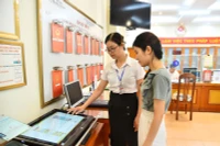 Cán bộ Ủy ban nhân dân phường Thanh Xuân Nam (quận Thanh Xuân, Hà Nội) hướng dẫn người dân thực hiện thủ tục hành chính trên môi trường mạng. Ảnh: Thuỷ Nguyên.
