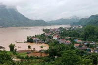 Nước ngập cánh đồng và cả nhà dân. (Ảnh: TUẤN SƠN)