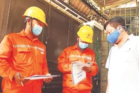 Công nhân Công ty Điện lực thành phố Thủ Đức hướng dẫn người dân sử dụng điện an toàn. 