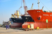 Những người thợ đóng tàu rảo bước trên cầu cảng Nam Triệu (thành phố Thủy Nguyên, Hải Phòng), bên cạnh là những tàu dầu 7.000 tấn vừa được đóng mới. (Ảnh THẾ ĐẠI)