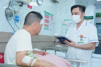 Nhân viên y tế Bệnh viện Bạch Mai sử dụng bệnh án điện tử trong quá trình thăm khám cho bệnh nhân.