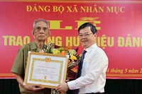 Đồng chí Nguyễn Văn Sơn, Phó Bí thư Tỉnh ủy, Chủ tịch Ủy ban nhân dân tỉnh Tuyên Quang trao Huy hiệu 75 tuổi Đảng cho đảng viên Lương Minh Thủ, chi bộ thôn Kai Con, Đảng bộ xã Nhân Mục, huyện Hàm Yên.