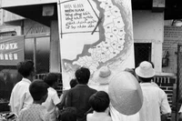 Nhân dân thị xã Phan Thiết (Bình Thuận) vừa được giải phóng theo dõi tin chiến thắng trên bản đồ chiến sự tại phòng thông tin thị xã (tháng 4/1975). (Ảnh: Mai Hưởng/TTXVN)