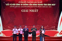 Đại tướng Phan Văn Giang (thứ 2, bên phải) và đồng chí Nguyễn Xuân Thắng (giữa) trao giải Nhất tặng các tác giả đoạt giải.