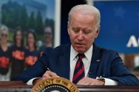 Tổng thống Mỹ Joe Biden ký một đạo luật tại Nhà Trắng. (Ảnh: AFP/TTXVN)