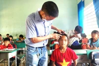 Cán bộ y tế xã kiểm tra tình hình sức khỏe học sinh, nơi có dịch bệnh thủy đậu. (Ảnh: Quang Nhật)