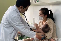 Tiến sĩ, bác sĩ Đỗ Thiện Hải, Phó Giám đốc Trung tâm bệnh Nhiệt đới, Bệnh viện Nhi Trung ương khám cho bệnh nhi mắc sởi. (Ảnh: HẢI NGÔ)