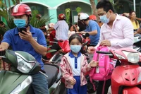 Nhiều trẻ em được bố mẹ đưa đến trường bằng xe máy. (Ảnh Ngọc Biểu)