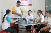 Giám đốc Hợp tác xã nông nghiệp Long Hiệp Trầm Minh Thuần (đứng) trao đổi kinh nghiệm với các cán bộ xã Lưu Nghiệp Anh, huyện Trà Cú, tỉnh Trà Vinh.