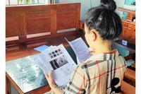 Chị Trần Thị Vy cùng với hồ sơ bệnh án tai biến do tiêm nâng mũi.