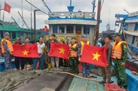 Cán bộ, chiến sĩ BĐBP thành phố Hải Phòng tặng cờ cho ngư bám biển. 