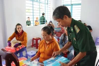 Lực lượng Biên phòng trao tặng áo phao và tài liệu pháp luật cho ngư dân. 