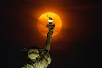 Siêu trăng mọc qua màn sương mù phía sau Tượng Nữ thần Tự do ở thành phố New York, Mỹ. (Ảnh: Getty Images)