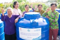 Phụ nữ Cà Mau nhận bồn chứa nước sinh hoạt trong khuôn khổ dự án “Nước là sự sống”. 