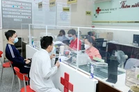Bệnh nhân và người nhà làm thủ tục thanh toán bảo hiểm y tế tại Bệnh viện Ung bướu Hưng Việt, Hà Nội. (Ảnh NGUYỄN ĐĂNG)