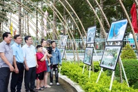 Người dân và chính quyền địa phương tham quan triển lãm ảnh. (Ảnh: HUỲNH LÃNH).