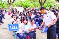 Báo cáo viên tuyên truyền, phát tờ rơi về thu hút nguồn nhân lực tại Trường THPT Hùng Vương, thành phố Quy Nhơn. (Ảnh THANH SANG)