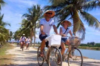 Du khách tham quan các làng quê Quảng Nam bằng xe đạp. (Ảnh: ĐÌNH TĂNG)
