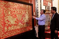 Ông Nguyễn Thế Hồng giới thiệu với du khách Tranh thêu chỉ vàng thời Nguyễn trưng bày trong Bảo tàng Hoàng gia Nam Hồng.