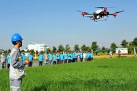 Kỹ sư của Công ty cổ phần Tập đoàn Lộc Trời trình diễn phun thuốc bảo vệ thực vật trên ruộng lúa bằng thiết bị bay không người lái. (Ảnh CÔNG MẠO)