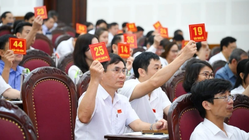 Các đại biểu biểu quyết thông qua Nghị quyết về việc tán thành chủ trương sắp xếp các đơn vị hành chính cấp xã trên địa bàn thành phố Vinh.