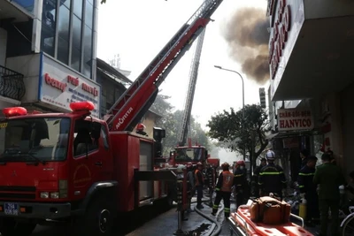 Lực lượng cứu hộ cứu nạn dùng xe thang để đưa thi thể hai nạn nhân xấu số trong vụ cháy tại số nhà 84 phố Lê Lợi ra ngoài.