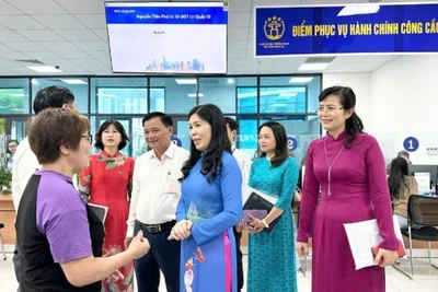 Lãnh đạo phường Cầu Giấy trò chuyện với người dân đến làm thủ tục hành chính. (Ảnh: HÀ PHONG)