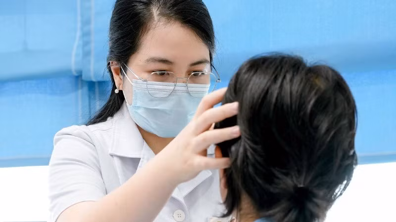 Bác sĩ Trần Thị Quyên thăm khám cho bệnh nhân bị viêm da tiếp xúc kích ứng nặng, bội nhiễm do biến chứng sau khi tẩy nốt ruồi tại một cơ sở đông y không bảo đảm chuyên môn.