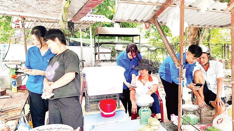 Đoàn viên, thanh niên Tỉnh đoàn Hưng Yên hướng dẫn người dân sử dụng điện thoại thông minh ứng dụng trên nền tảng số.