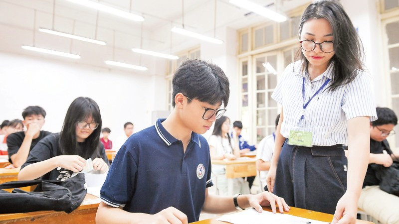 Giám thị kiểm tra phiếu dự thi của thí sinh kỳ thi tuyển sinh lớp 10 THPT công lập tại điểm thi Trường THPT Trần Phú, quận Hoàn Kiếm. (Ảnh THẾ ĐẠI)