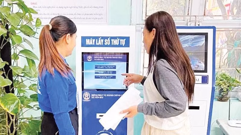 Người dân lấy số thứ tự tự động tại Điểm Phục vụ hành chính công xã Yên Bài (Hà Nội).