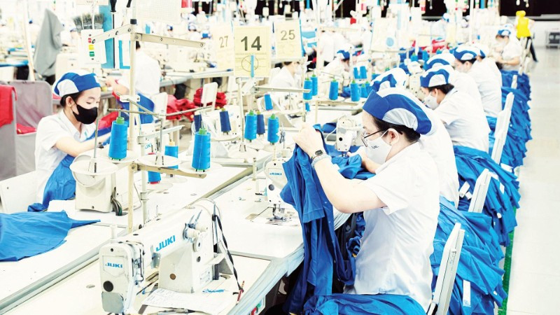 Công nhân làm việc tại một dây chuyền may mặc của Tổng Công ty cổ phần May Việt Tiến.