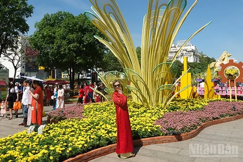 Người dân đến chụp ảnh tại Đường hoa Nguyễn Huệ từ sớm trong ngày mùng 1 Tết. (Ảnh: Linh Bảo)