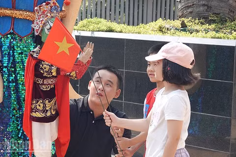 Các em nhỏ thích thú khi được làm quen với các nhân vật rối. (Ảnh: Linh Bảo).